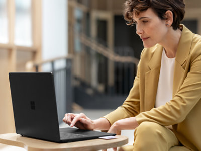 A person sitting at a table using a laptop.