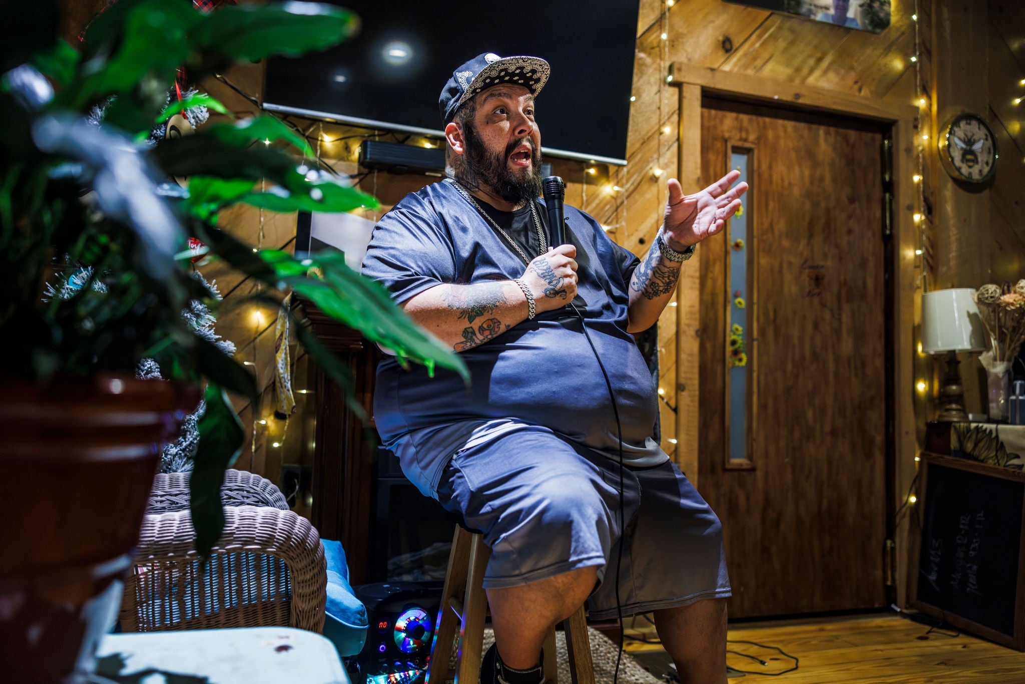 Overweight man singing into a microphone at a bar