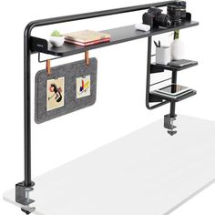 a black shelf with two pictures hanging from it's sides and a camera next to it