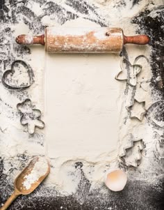 baking utensils and cookie cutters sit on a floured surface