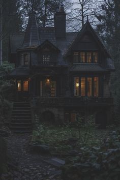 a house in the woods with stairs leading up to it's windows at night