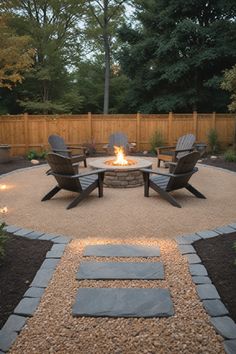 a fire pit surrounded by chairs and gravel in the middle of a backyard with lights on it