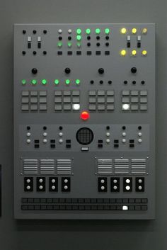 the control panel on the wall has many different buttons and numbers in it, including two red lights