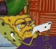 an image of a spongebob with glasses holding up a cell phone in front of him