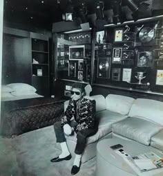 a man sitting on top of a white couch in a living room