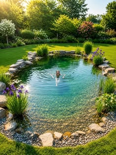 a woman swimming in a pond surrounded by rocks and grass, with flowers around it