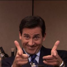 a man in a suit giving the thumbs up sign