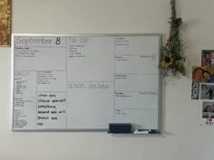 a dry erase board mounted to the side of a white wall with pictures on it