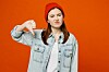 Someone in a red beanie hat giving a thumbs down
