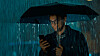 Man caught in the rain on his phone