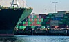 Dockworkers tying up container ship to dock with stacked containers in the background at the Port of Los Angele