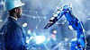 A person next to an industrial robot