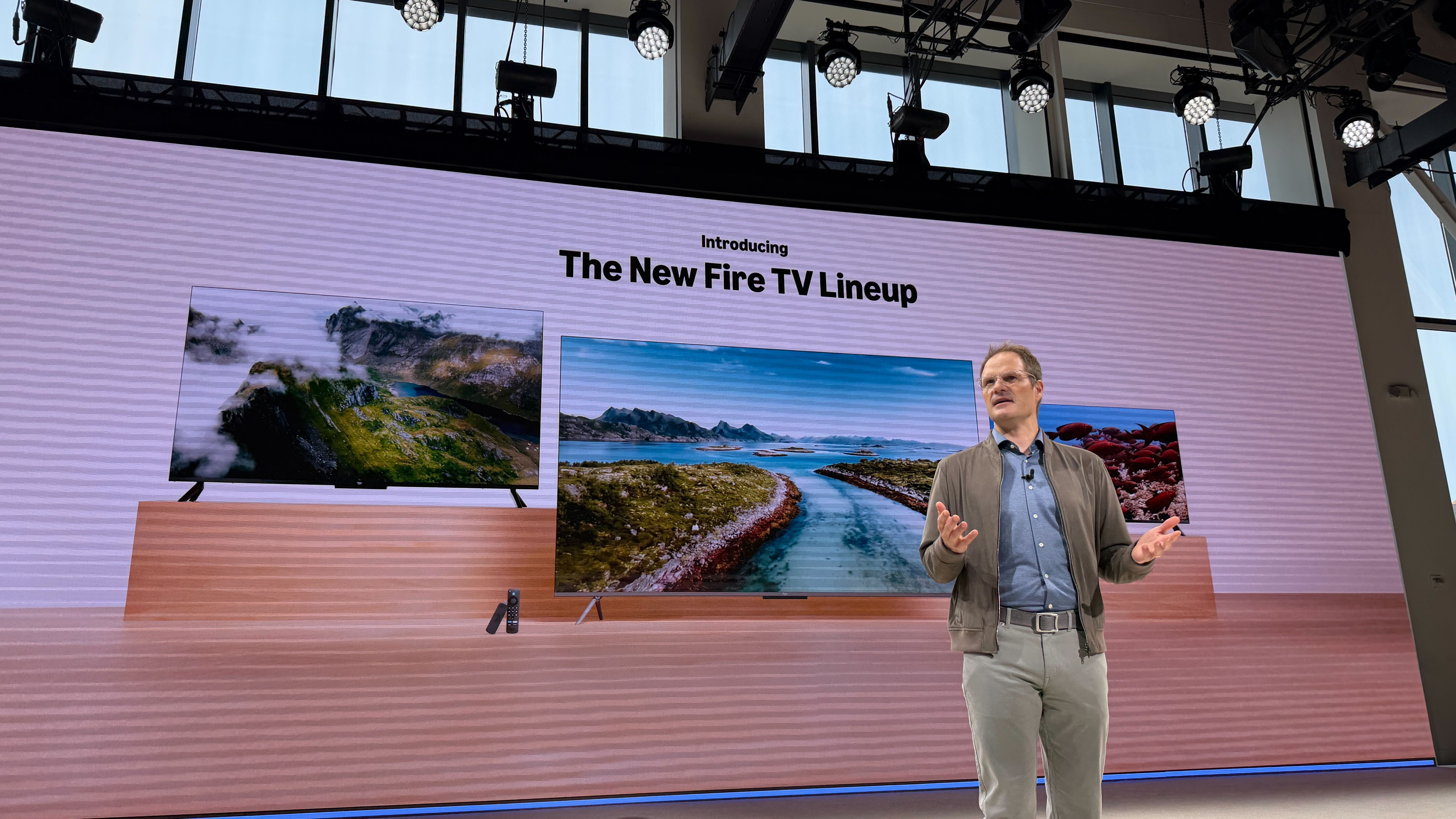 A presenter in front of a screen with the new Amazon Fire TV line-up on it