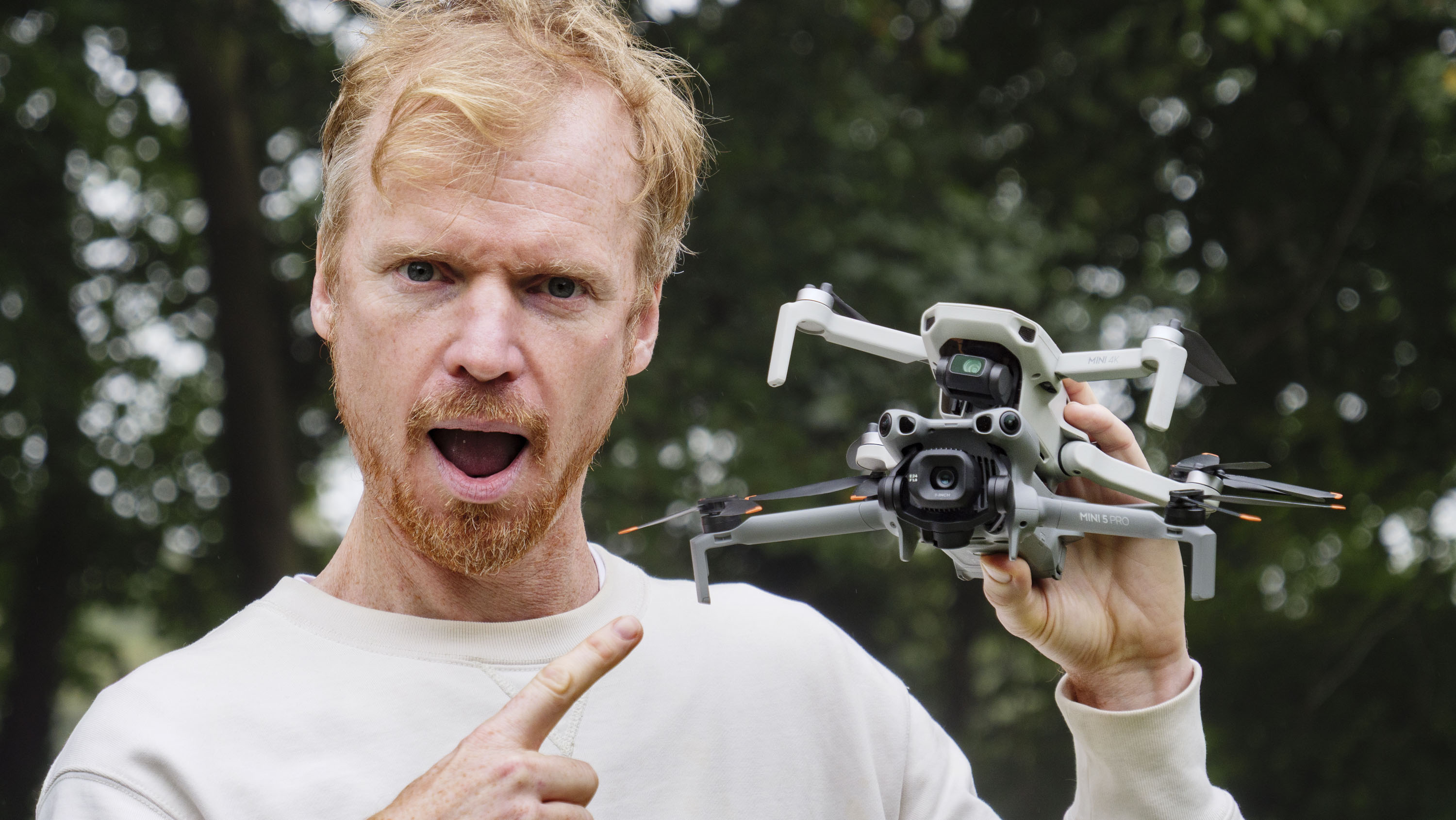 DJI Mini 5 Pro and DJI Mini 4K drones held by side by side