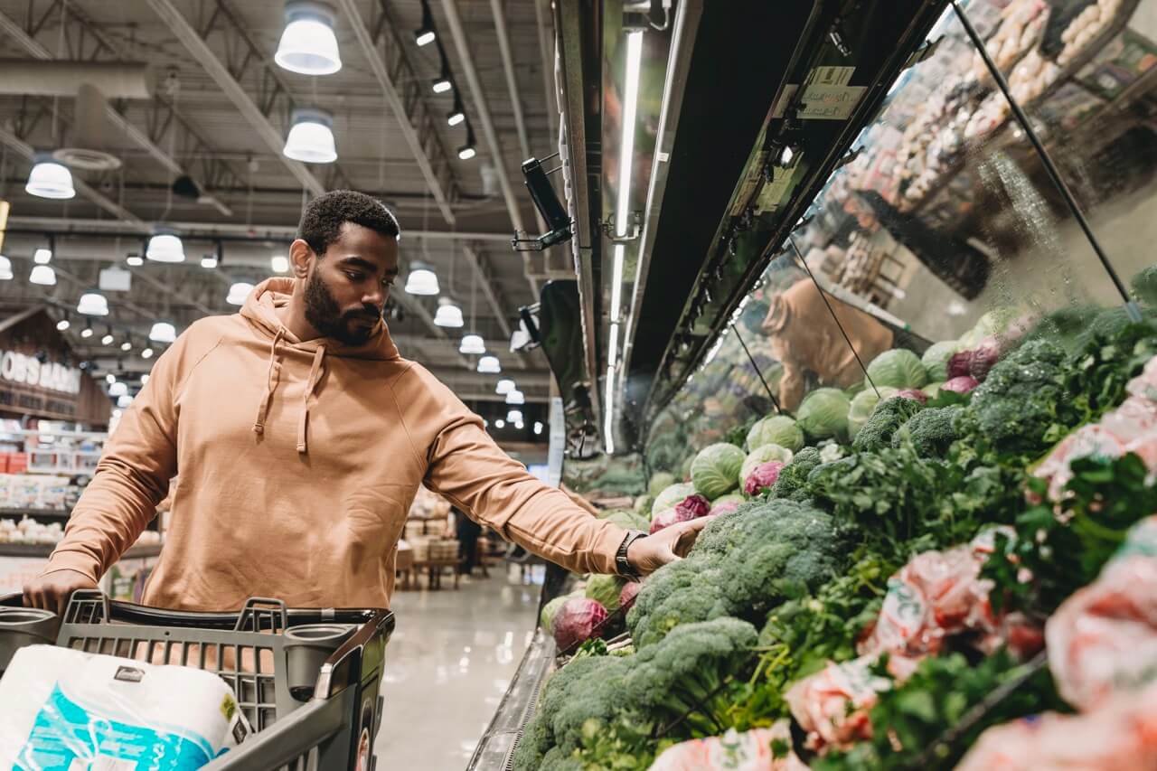 Man shopping for vegetables in a grocery store.