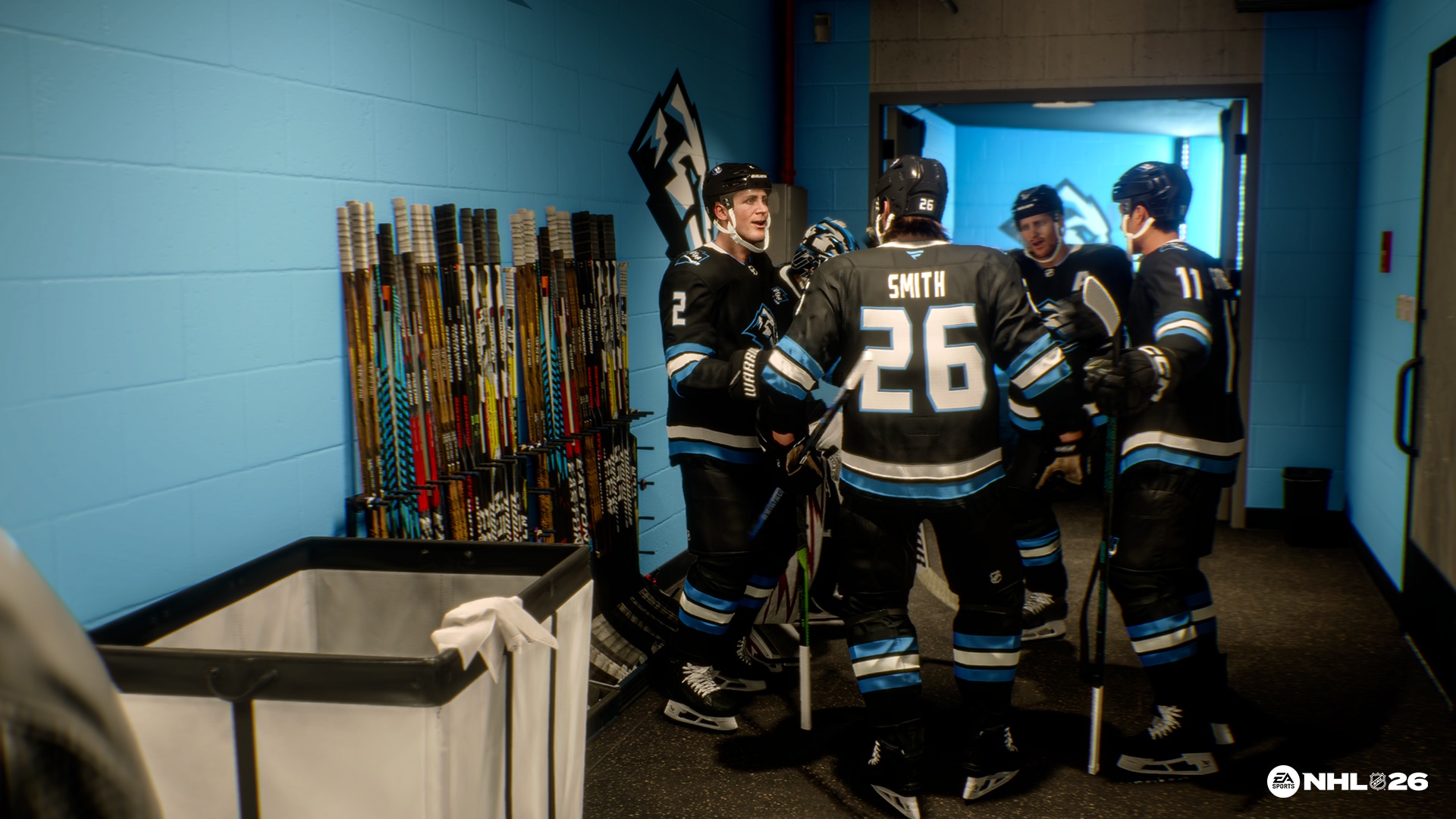 In game screenshot of NHL 26, a group of players wearing black and blue uniforms discussing in a circle
