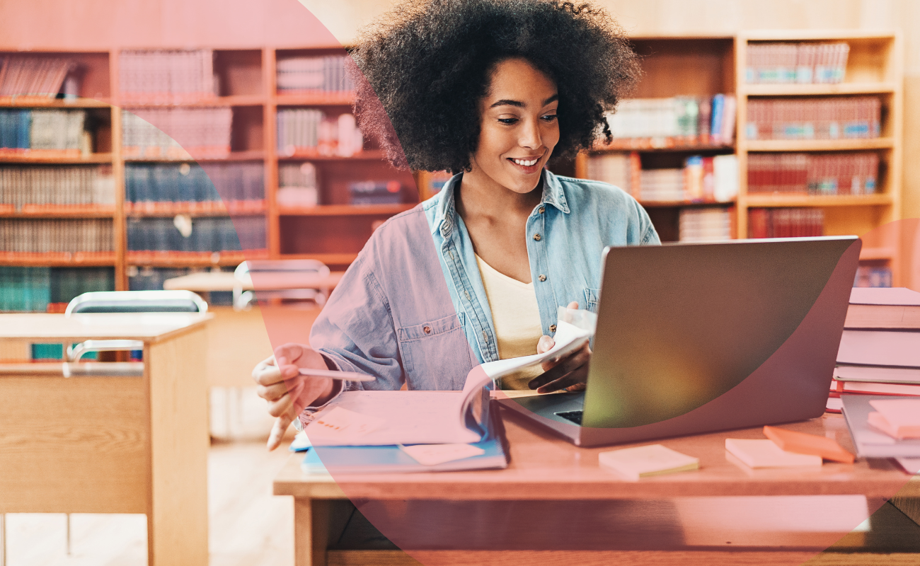 Woman sat at desk using a laptop.