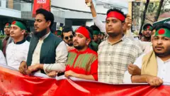 এনসিপির নেতারা মাথায় বাংলাদেশের পতাকা বেঁধে ও একটি ব্যানার ধরে মিছিল করছেন, গত ১৬ই ডিসেম্বরের ছবি