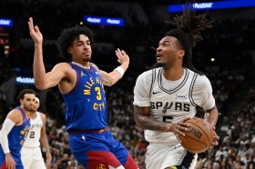Nuggets Spurs Basketball San Antonio Spurs guard Stephon Castle (5) drives against Denver Nuggets guard Julian Strawther during the first half of an NBA basketball game, Sunday, April 12, 2026, in San Antonio. (AP Photo/Darren Abate)