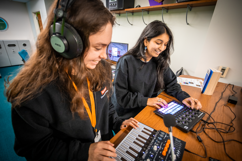 2 people interacting with synthesizers