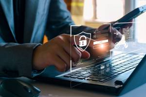 Person sitting at a laptop computer with an illustrated overlay of screen information like site log in and personal details