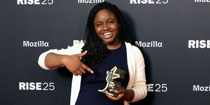 Rise25 award recipient pointing at her trophy.