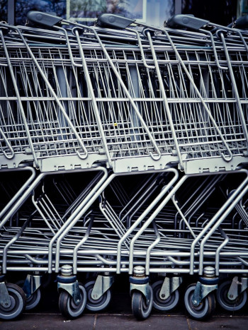 A close up shot of a group of metal supermarket trolleys.
