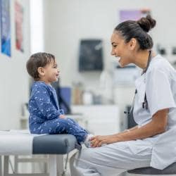 Nurse talking to a toddler on exam table