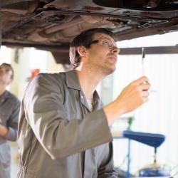 Technician inspecting car